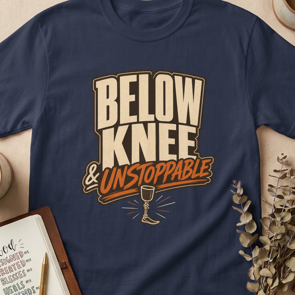 Navy t-shirt with "BELOW KNEE & UNSTOPPABLE" text and a prosthetic leg graphic.