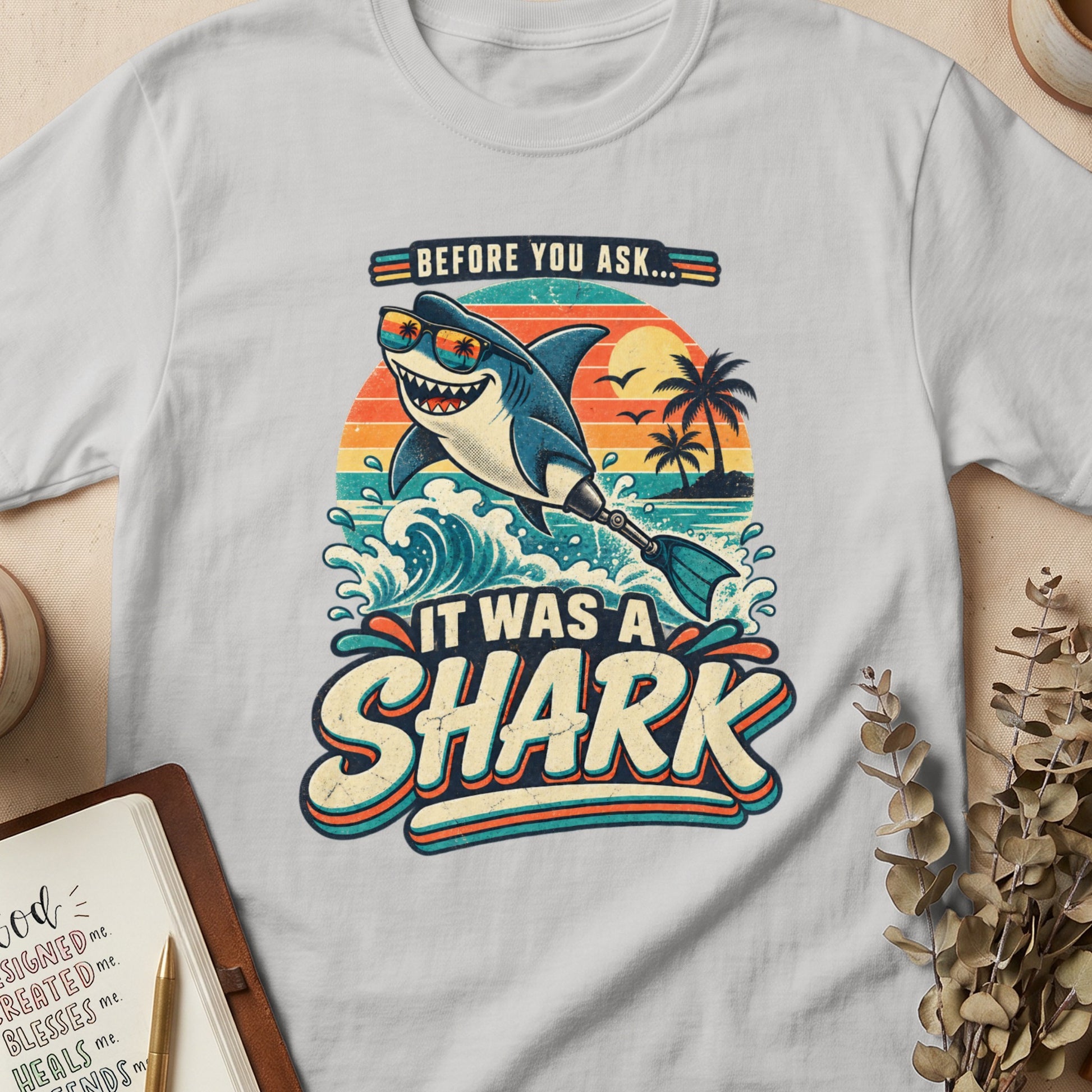 Retro cartoon shark with sunglasses and a prosthetic fin, "Before You Ask... It Was A Shark".