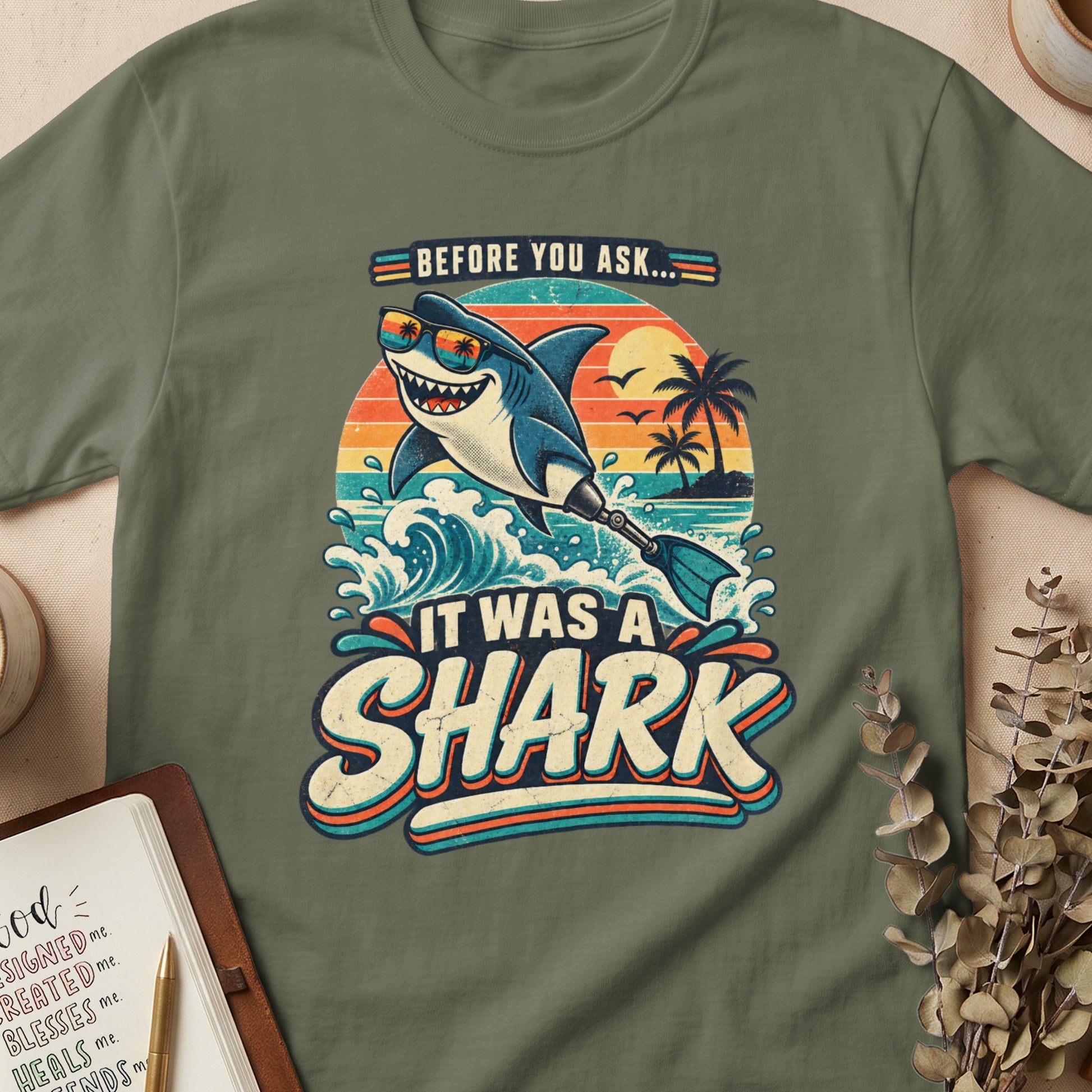 A cartoon shark wearing sunglasses surfs at sunset with text "Before you ask... It was a shark".