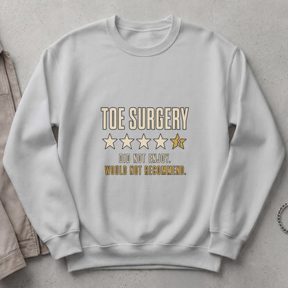 White sweatshirt with "TOE SURGERY DID NOT ENJOY. WOULD NOT RECOMMEND." text and stars.