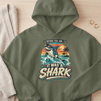 Green hoodie with a shark wearing sunglasses and a prosthetic fin, text "Before You Ask... It Was A Shark".