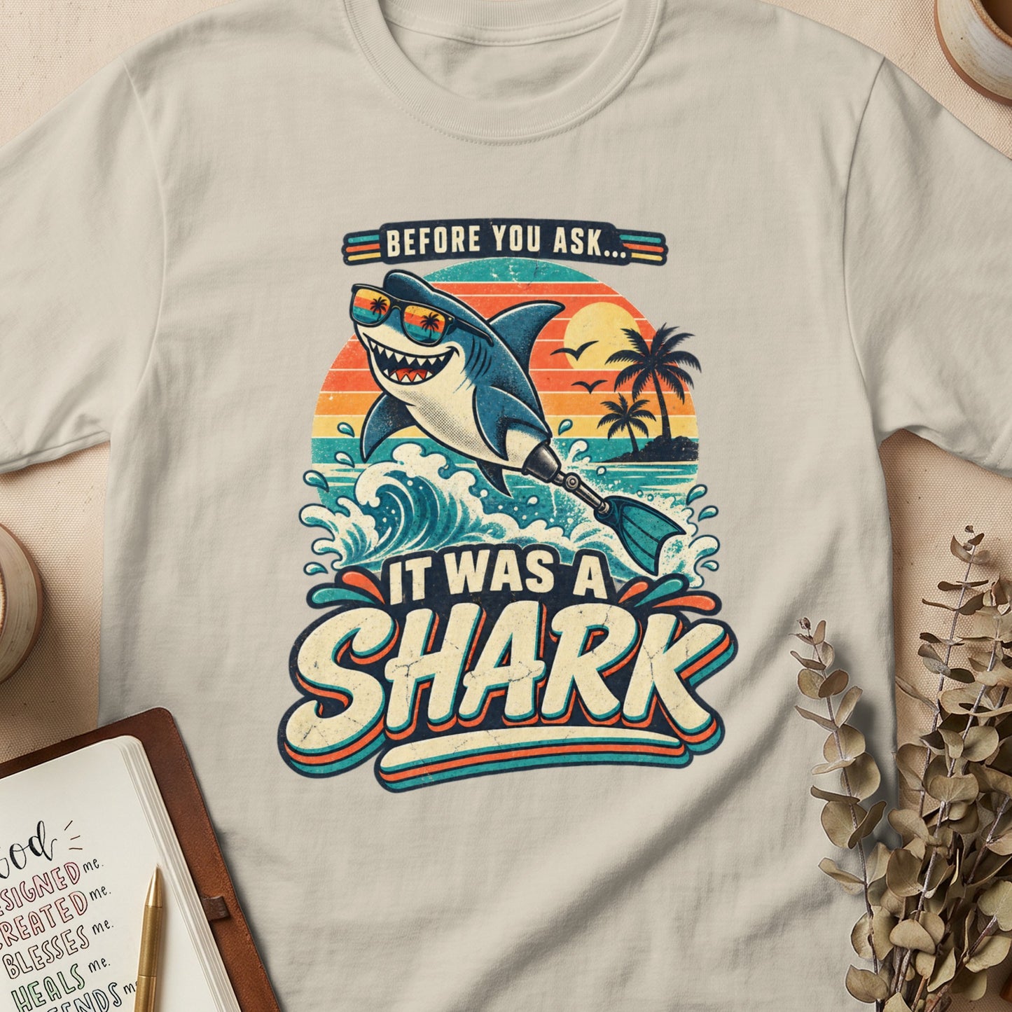 T-shirt graphic with a smiling shark in sunglasses saying "It Was A Shark."