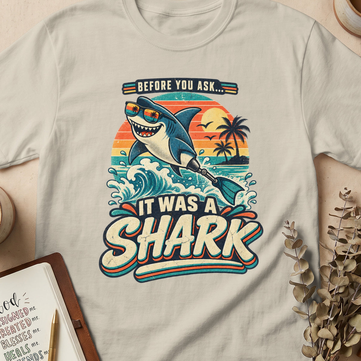 T-shirt graphic with a smiling shark in sunglasses saying "It Was A Shark."
