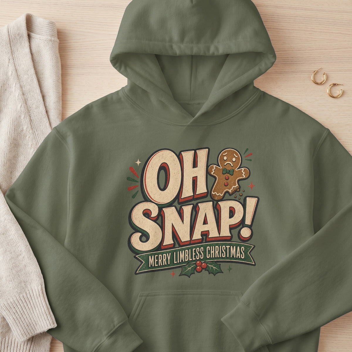 Olive green hoodie with "Oh Snap! Merry Limbless Christmas" text and gingerbread man graphic.