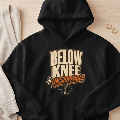 Black hoodie with "BELOW KNEE & UNSTOPPABLE" text and prosthetic leg graphic.