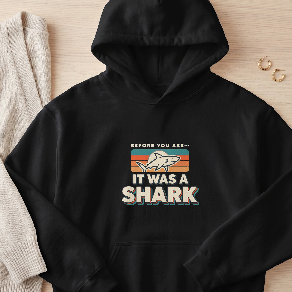 Black hoodie with "Before you ask... It was a shark" graphic design.