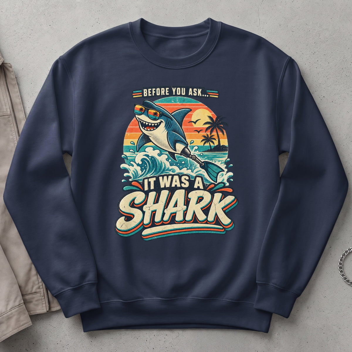 "Before you ask... it was a shark" graphic on a navy sweatshirt.