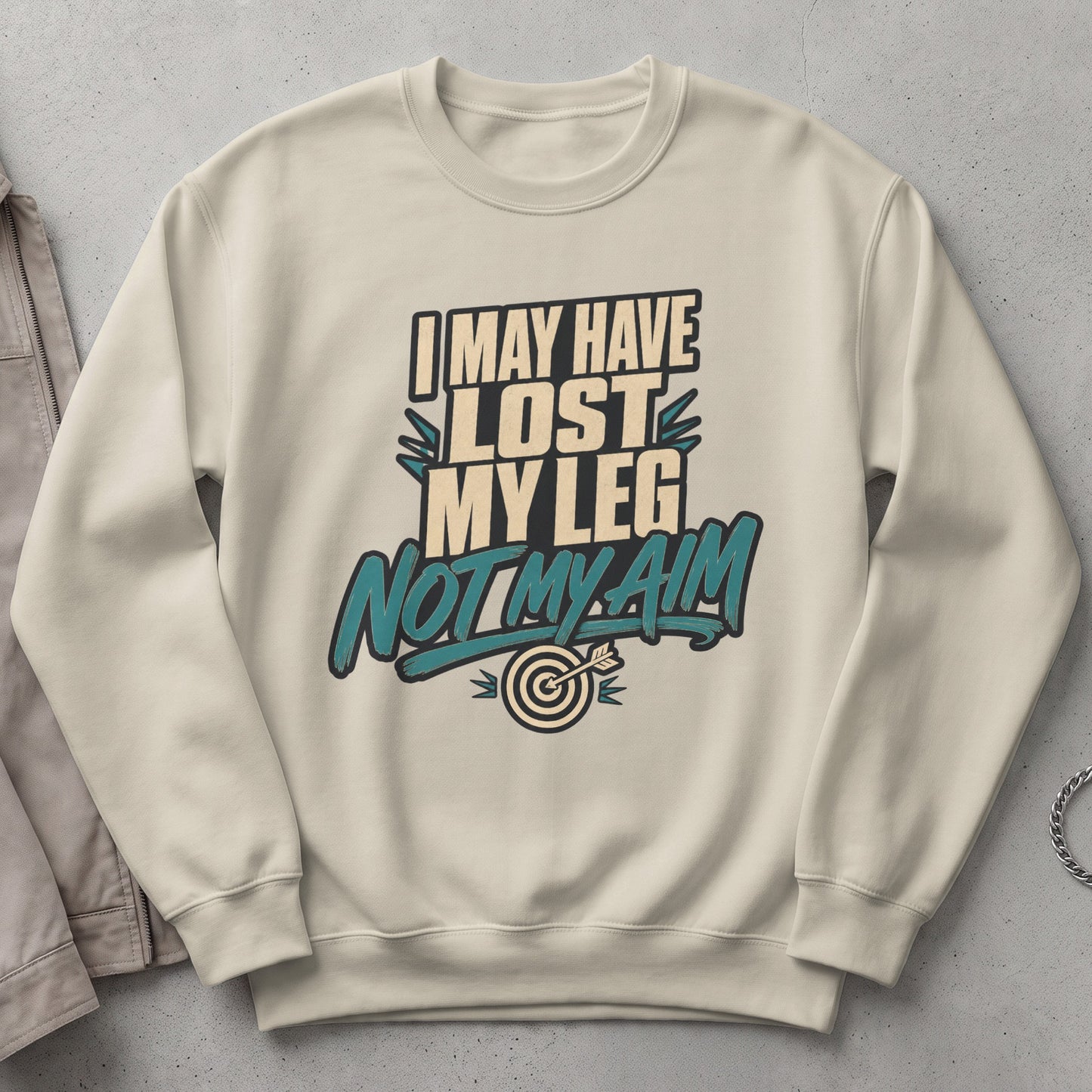 Cream sweatshirt with text "I MAY HAVE LOST MY LEG NOT MY AIM" and a target.