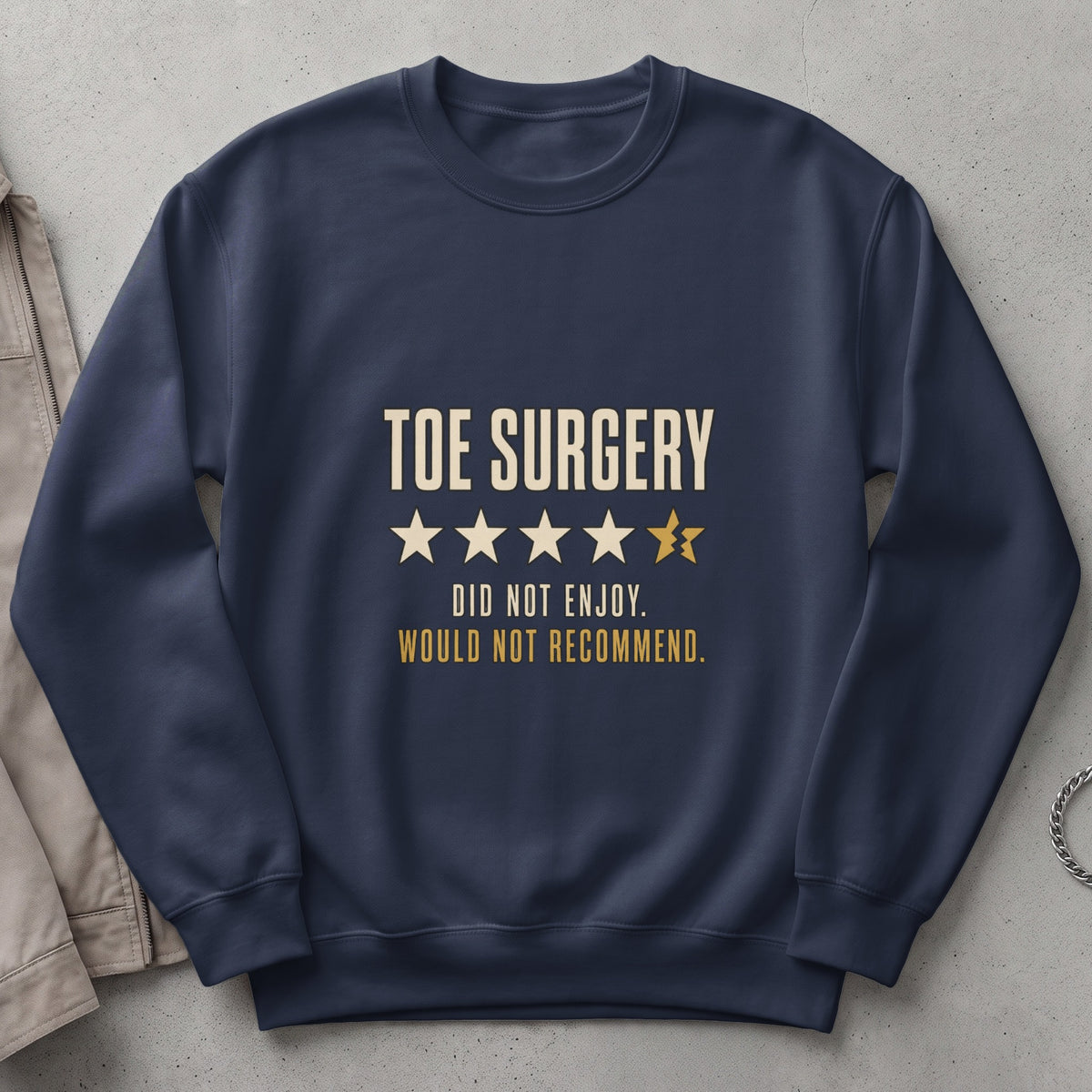 Dark blue sweatshirt with "TOE SURGERY" text and a broken star rating.