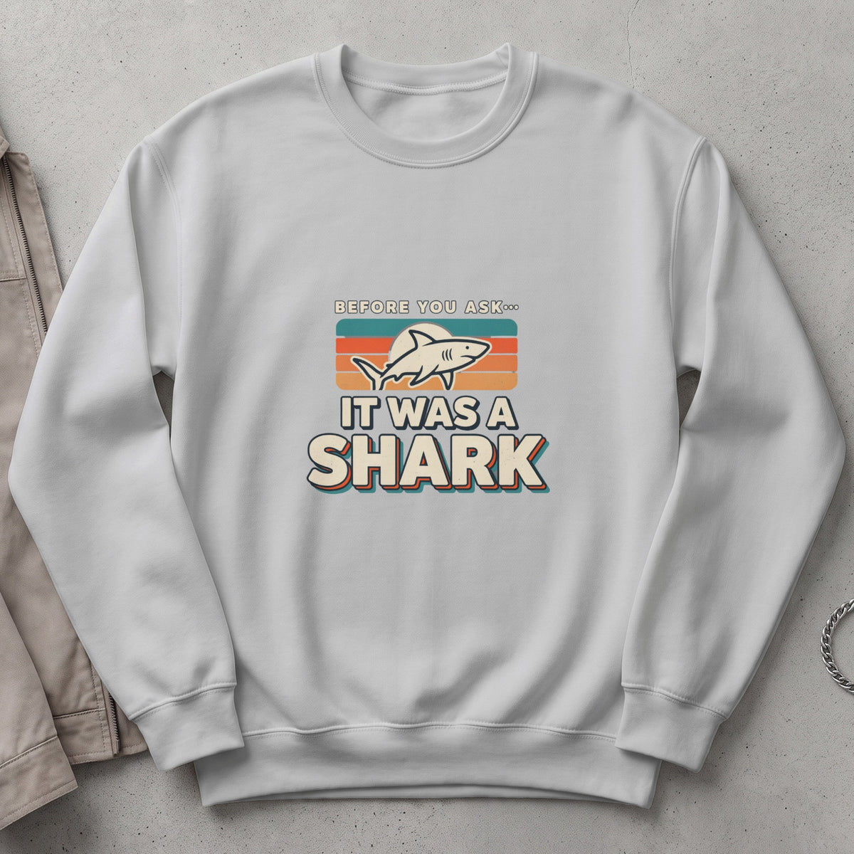 White sweatshirt with "Before you ask... It was a shark" graphic and shark illustration.
